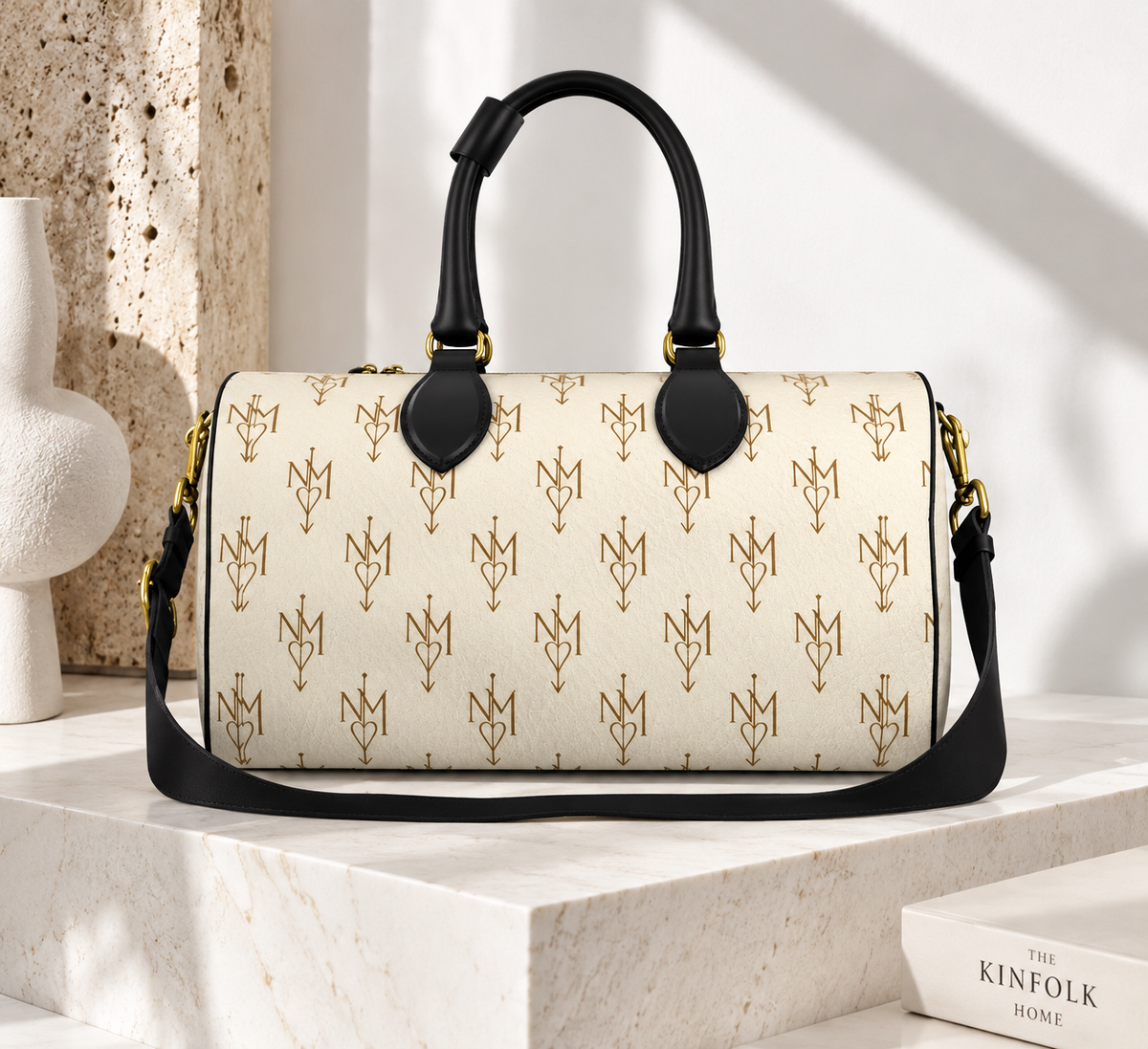 A structured satchel handbag with a cream-colored coated canvas body, covered in a repeating gold monogram pattern, featuring black leather top handles and a black shoulder strap with gold hardware.